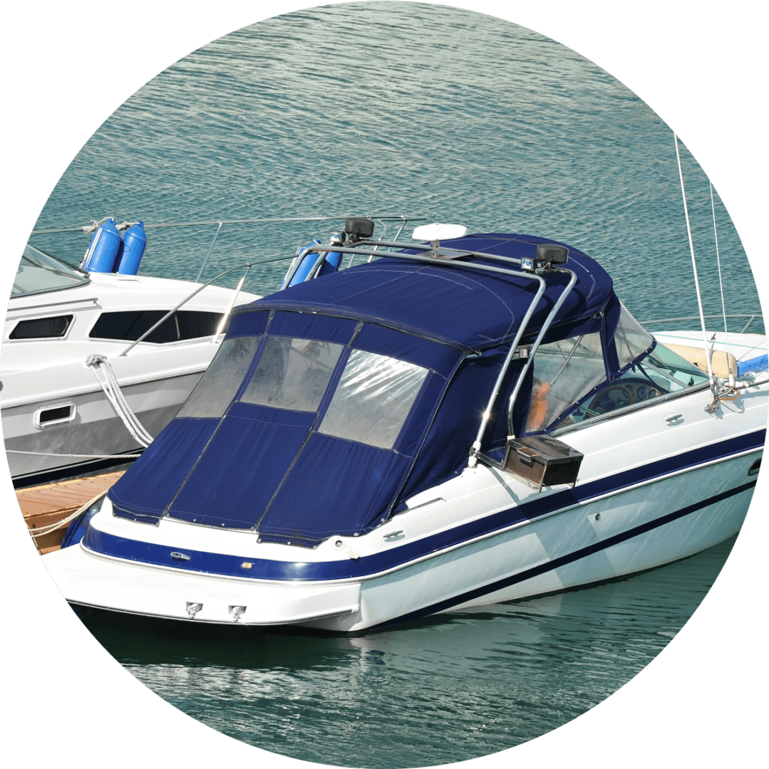 GettyImages-617390368 A white and blue motorboat with a navy canopy is docked next to another boat on calm water.